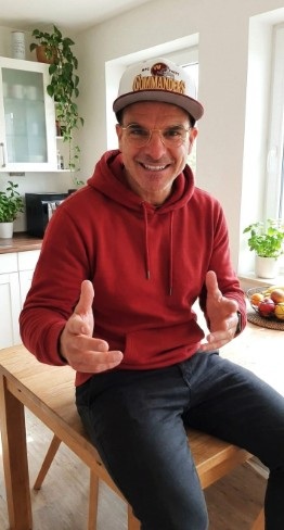Rasmus im persönlichen Gespräch, lächelnd mit offenen Händen